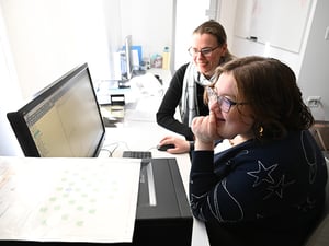 Student and professor work together with neurology equipment.