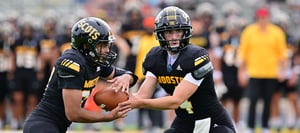 Football player passing ball to another player
