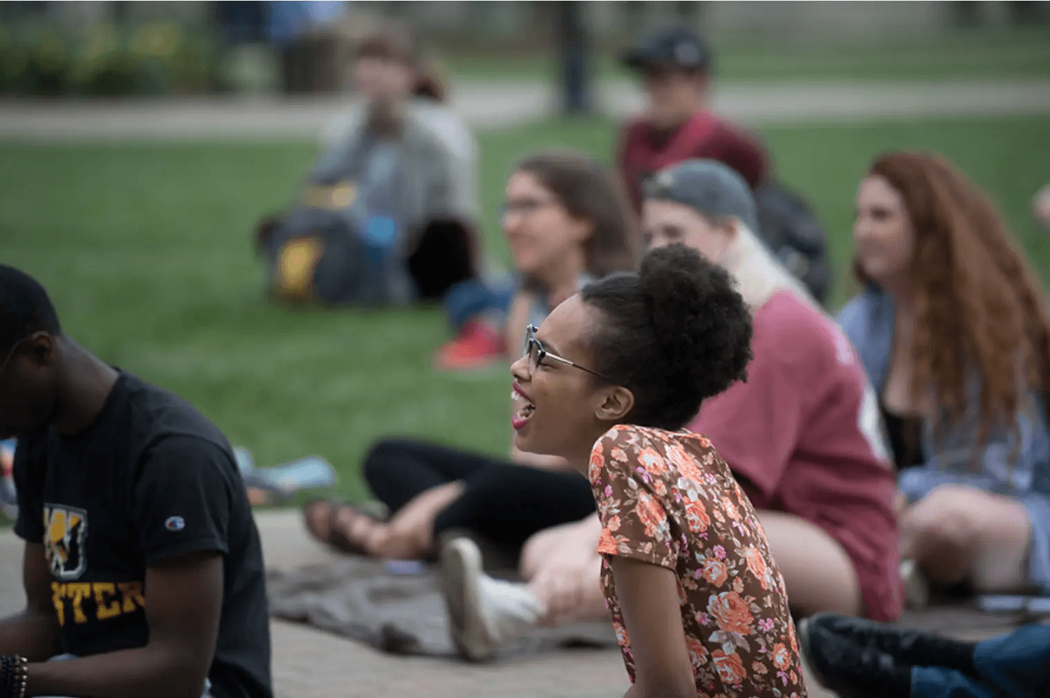 student laughing on campus lawn