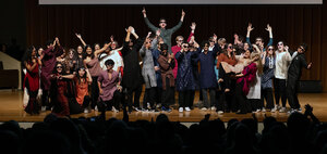 Students in colorful attire celebrate onstage during Wooster’s International Education Week Culture Show as audience members cheer.