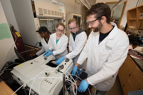 Jenelle Booker ’21, Prof. Jennifer Faust, Shayna Vicker ’21 and Kevin Wokosin ’18 measure the reactions of the molecules in rainwater as they interact with the atmosphere.