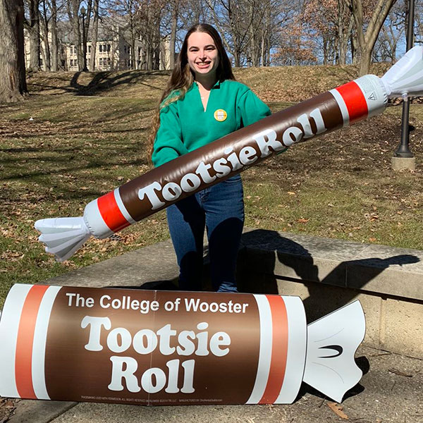 Photo of Laura Peterjohn holding an inflatable Tootsie Roll
