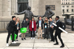 Students from The College of Wooster pose in front of Ben Franklin and George Washington statues