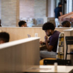 A student at The College of Wooster studies on a laptop in the newly renovated dining area of the Lowry Center.