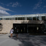 Two students walk outside the front of the Lowry Student Center at The College of Wooster.