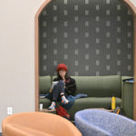 A student studying in the green theme room on the second floor of Lowry Center at The College of Wooster.