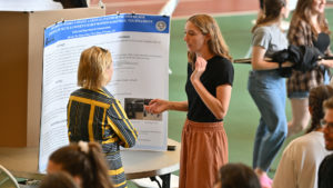 A student presents at the Poster Session of the I.S. Symposium