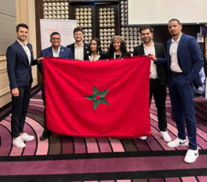 Yasmine Fazazi and her teammates pose with the Moroccan flag and their mentors at the competition.