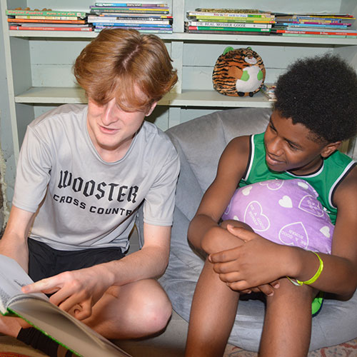 Will Callender '25 reading to a camper.