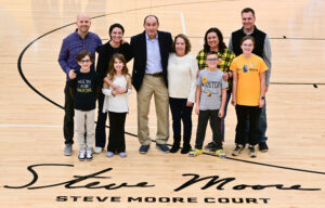 The Moore Family stands behind the inscription of Steve Moore Court