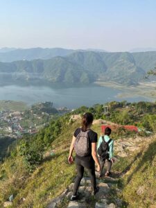 n a trip to investigate an issue involving the placement of power lines near a local community, Day and colleagues trek down a mountainside that overlooks a Nepali village