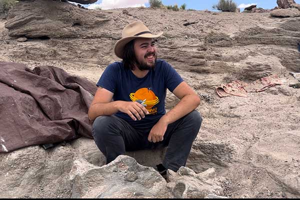 Hudson Davis '24 on a field site with a sauropod hip
