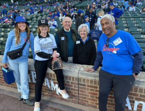 President McCall and her husband, Ravi Palat, and daughter, Berenice Saint-Saens, pose from Wrigley Field with Wooster trustee emeritus Jim McClung ’59, and his wife, Jean McClung.