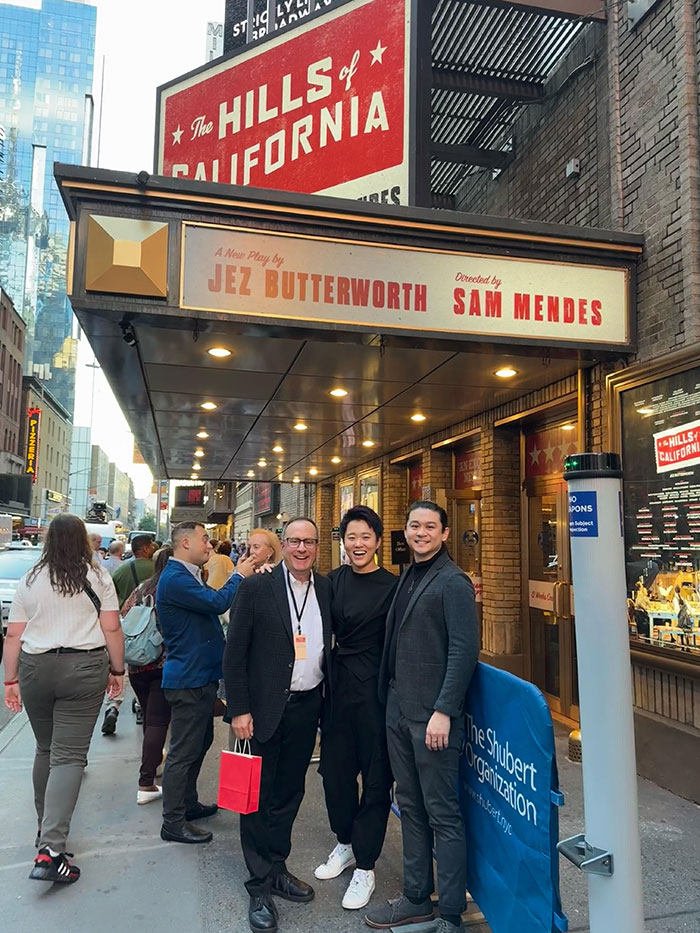 Harry Cheng '15 (right) poses with his mentor, Brian Spector (left) and producing partner, Jiani Bai in front of the marquee of their Tony-nominated production, The Hills of California.